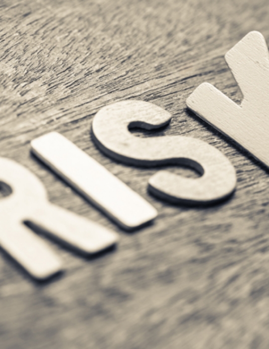 The word risk sitting on a wooden board