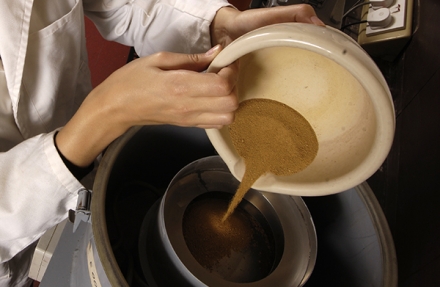 Scientist pouring dust into a machine