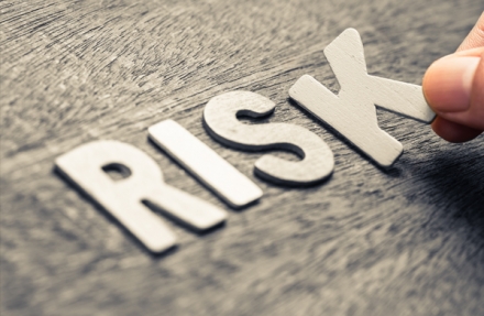 The word risk sitting on a wooden board